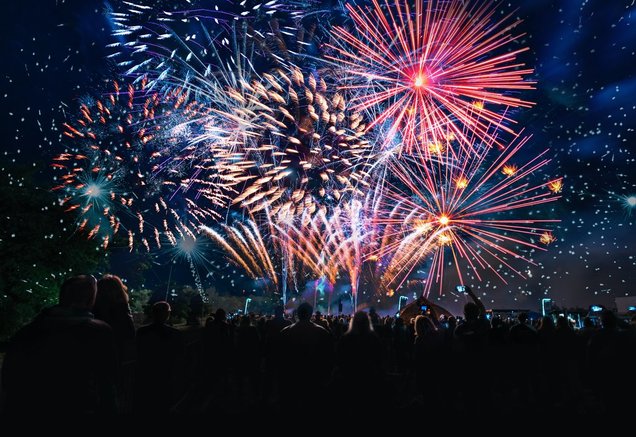 professional fireworks display over large crowd 