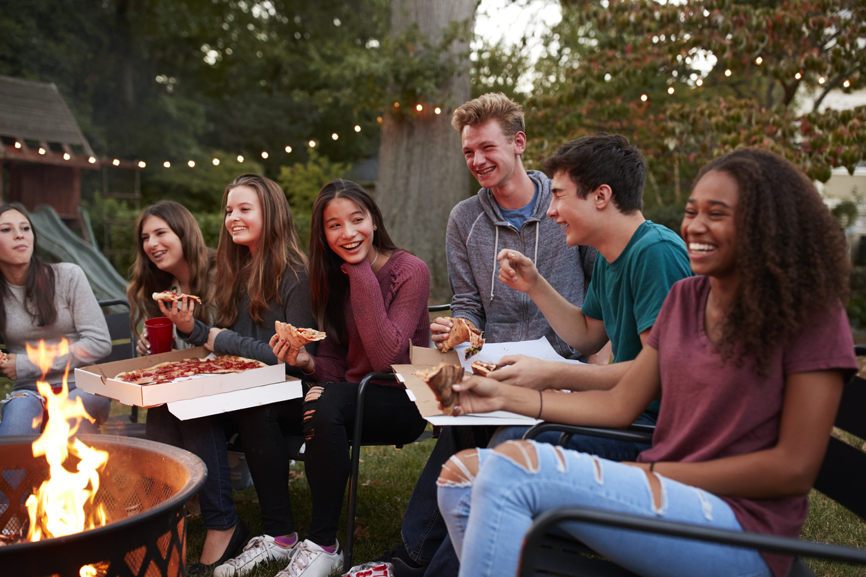 Group of Teens Hanging Outside Eating Pizza