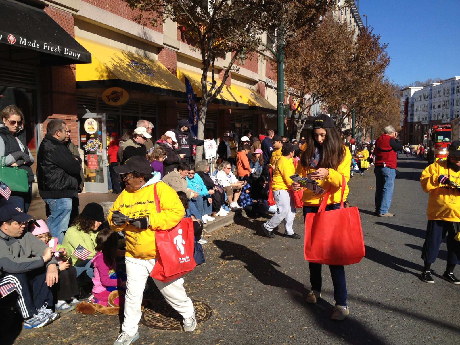 Photo of volunteers handing out reflective materials to the crowd at the 2012 Thanksgiving Parade