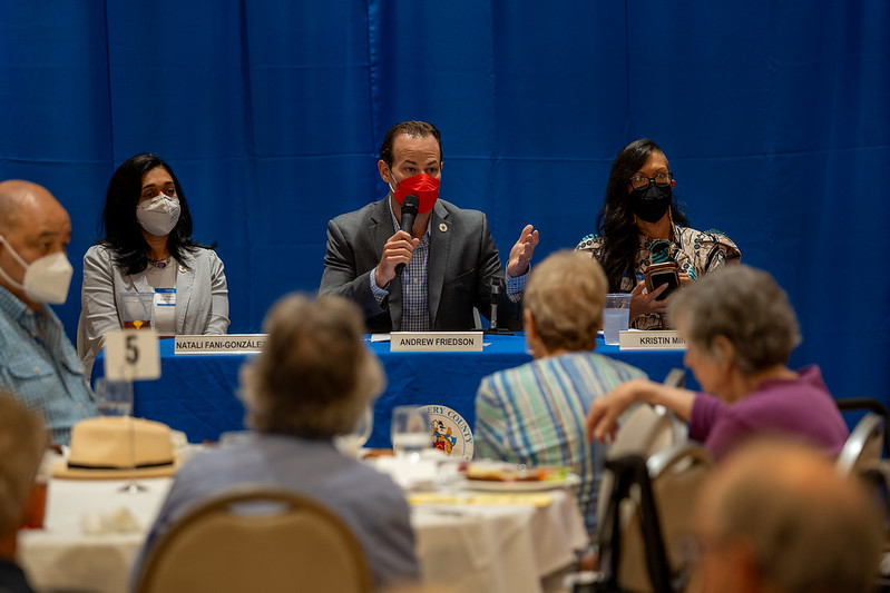 El presidente del Concejo Andrew Friedson habla desde una mesa a los residentes de Leisure World con miembros del Concejo.