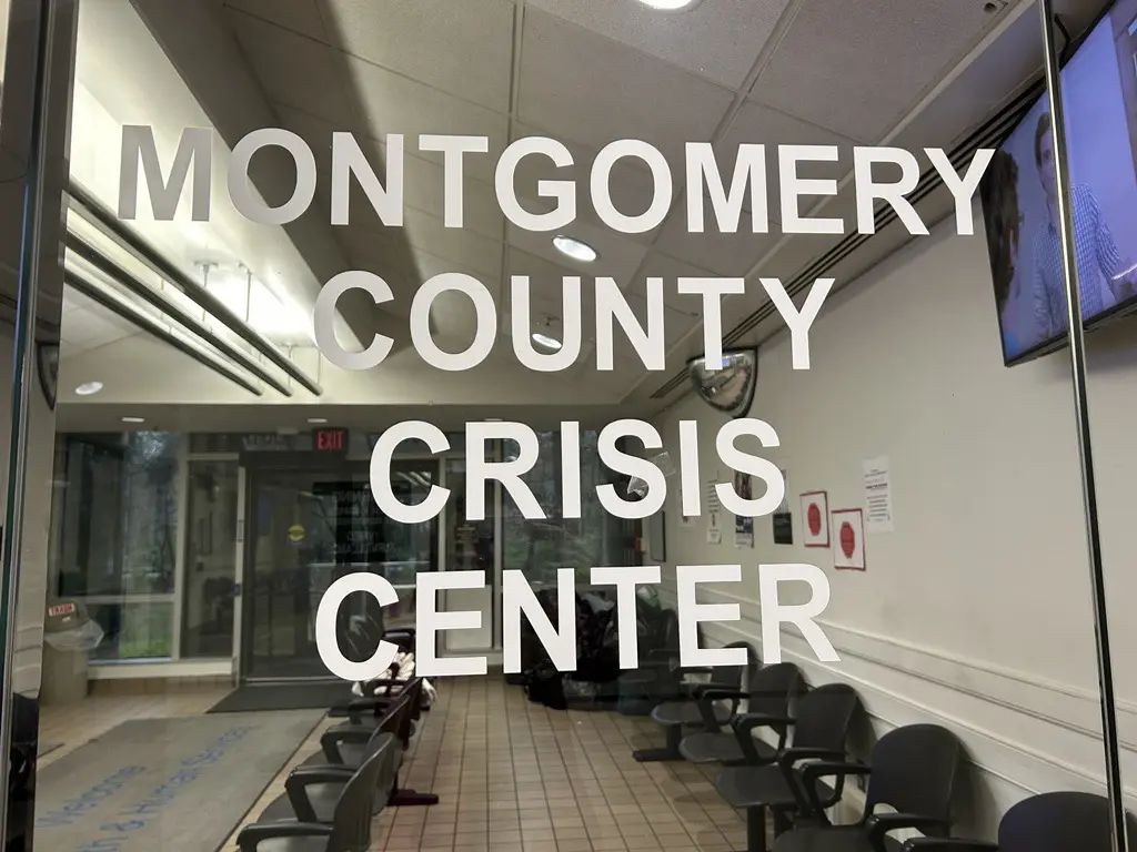 Ventana con un letrero que se lee en inglés como “Montgomery County Crisis Center”, en español “Centro de Crisis del Condado de Montgomery” en blanco. Crédito: Bethesda Today.