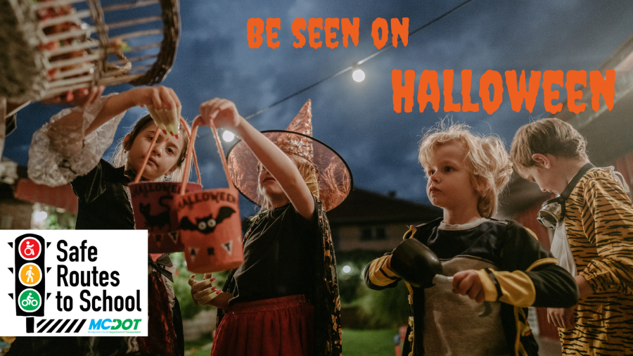 Children in Halloween costumes holding decorated buckets. Text: 'Be seen on Halloween.' Logo reads: 'Safe Routes to School.'