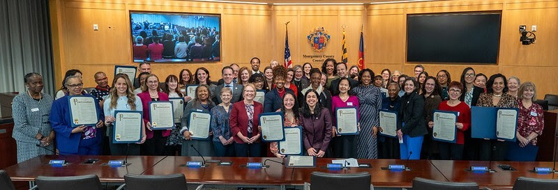 A large group of women and Councilmembers gather in Council chamber for Women’s History Month proclamation.