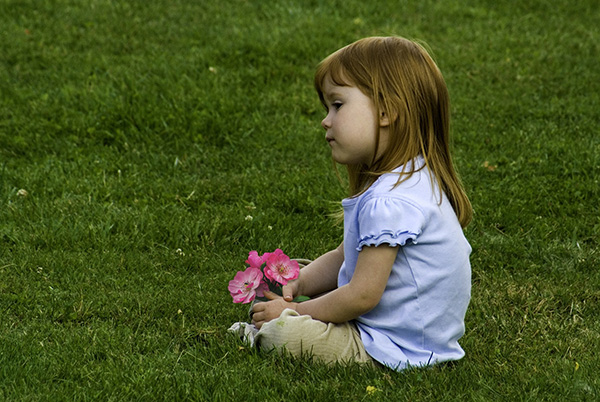 Girl sitting in grass. Credit: Oregongal
