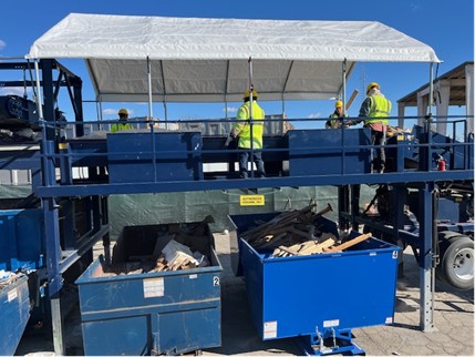 Photo of two workers on a platform sorting C&D materials delivered as waste to the Montgomery County Shady Grove Processing Facility and Transfer Station