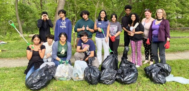 Council Member Natali Fani-González and DEP staff and students posing with bags of litter.