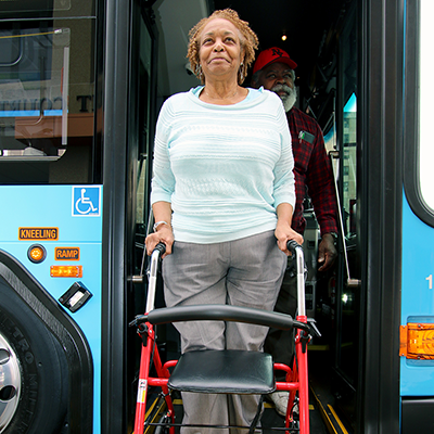 person with a walker at a bus entrance