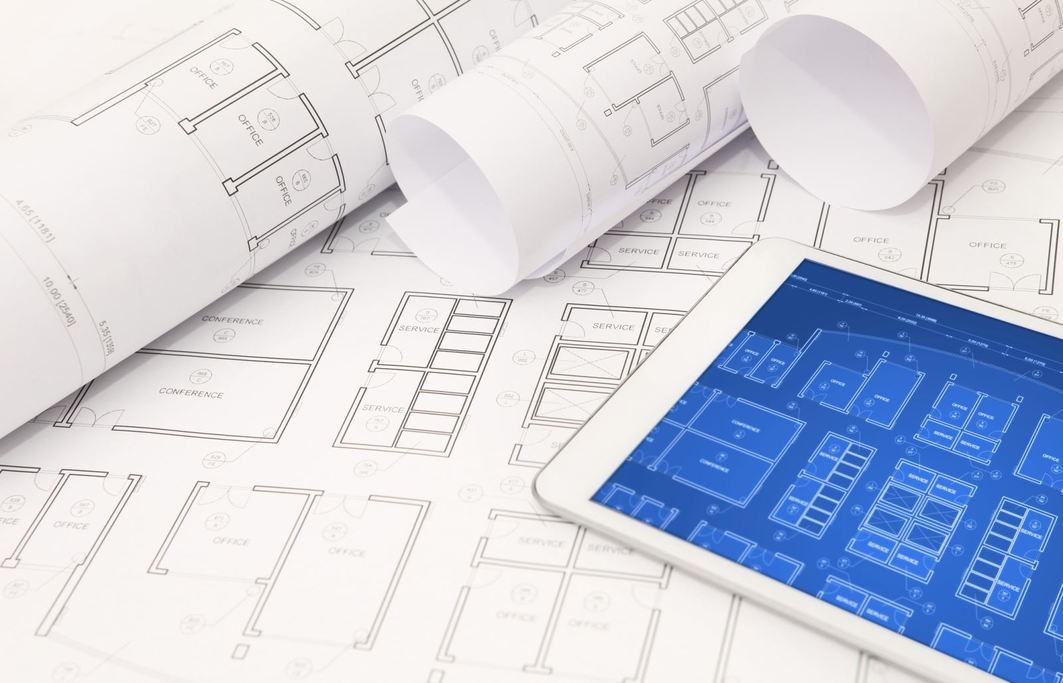 paper and electronic plans on a plan review table