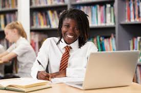 image of student in library studying in front of laptop