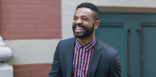 Smiling man in suit jacket and plaid shirt