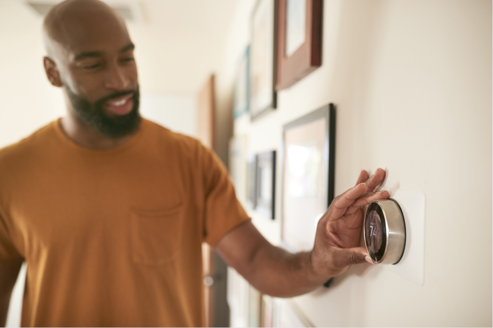 Man adjusting the temperature on a thermostat