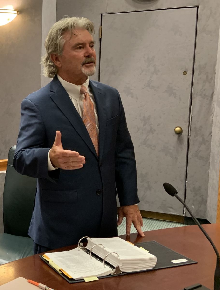 John McCarthy standing in front of a desk