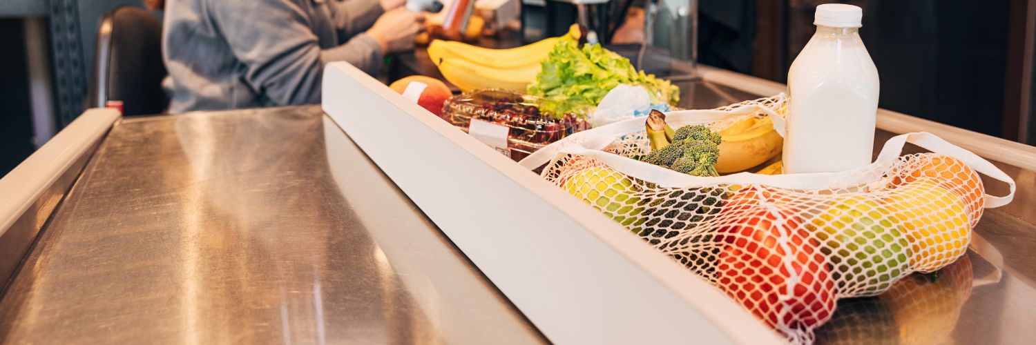 cashier bagging groceries with reusable bags