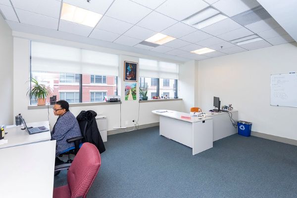 worker sitting at a desk in a light-filled co-working space