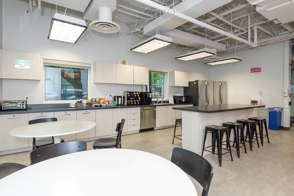 kitchen with refrigerators, tables, and chairs