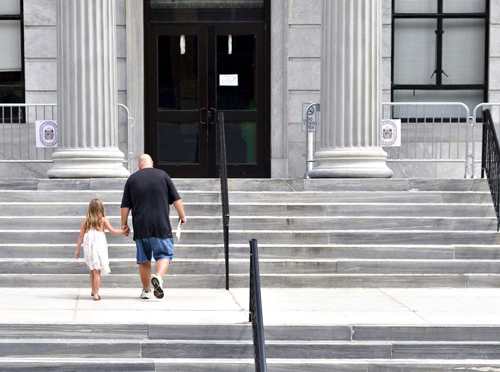 a man and a child walk up court steps