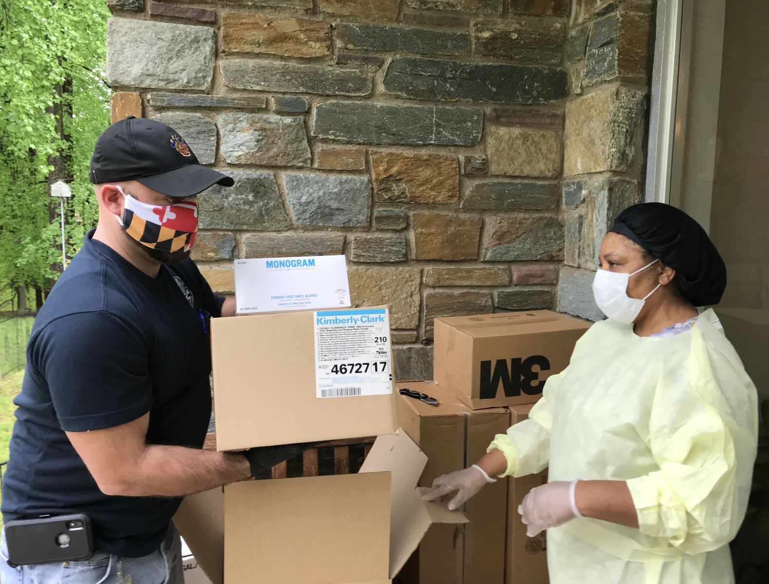 person delivering boxes of personal protective equipment to nursing home worker