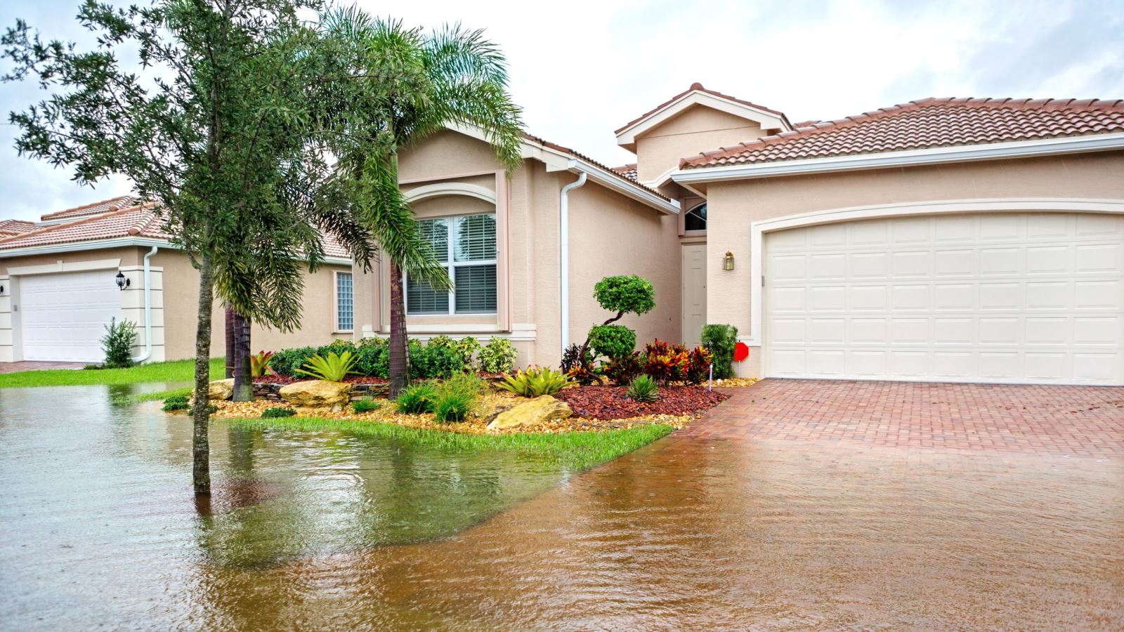 Single family home with flooded front yard and driveway.
