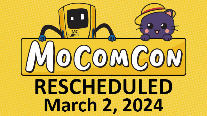 Robot and cat holding MoComCon 2024 sign