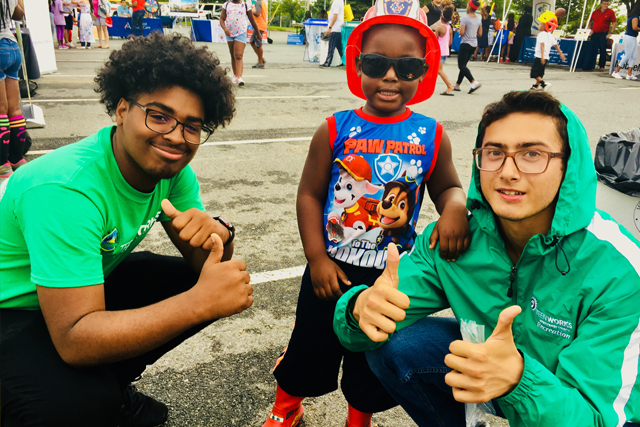 TeenWorks employees at fair with a child