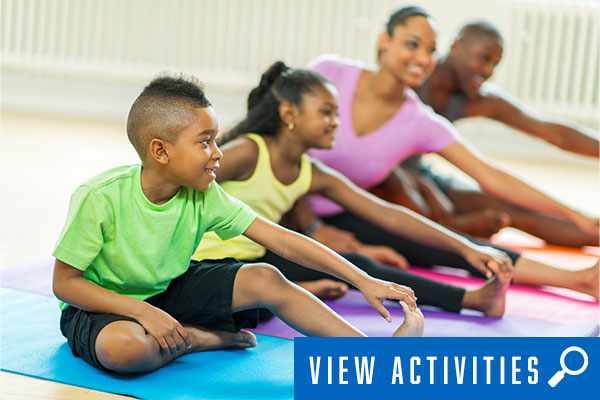 family doing yoga stretches, click to register for health and wellness classes