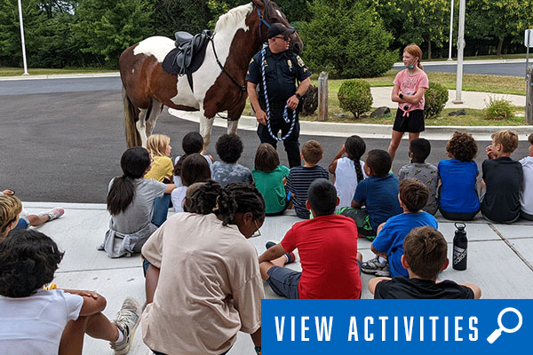 campers learning from police, click to register for special interest camps