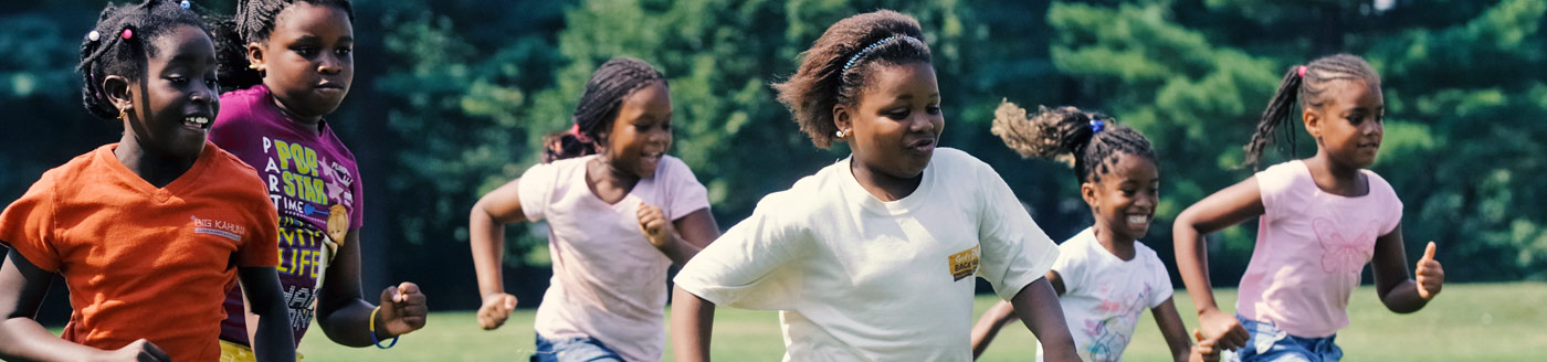 children running after soccer ball