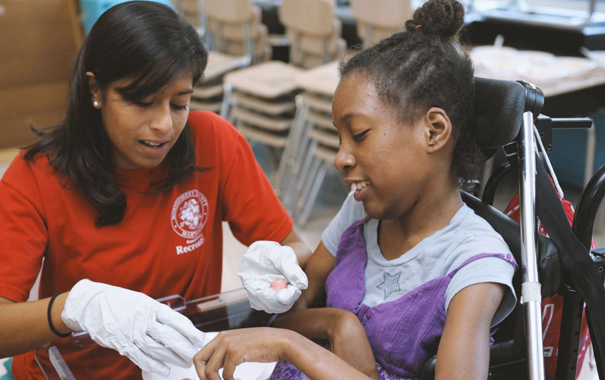 volunteer helping child in wheelchair