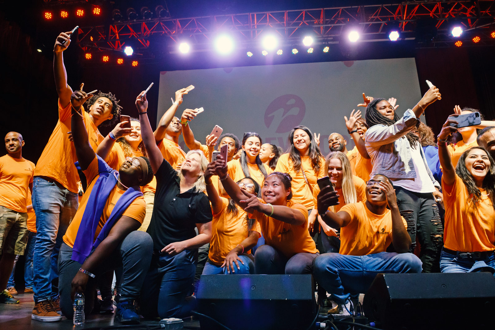 group of teens on stage taking selfies